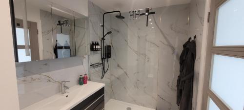a white bathroom with a shower and a sink at Atlantic Way Suites Doonbeg Co Clare in Doonbeg