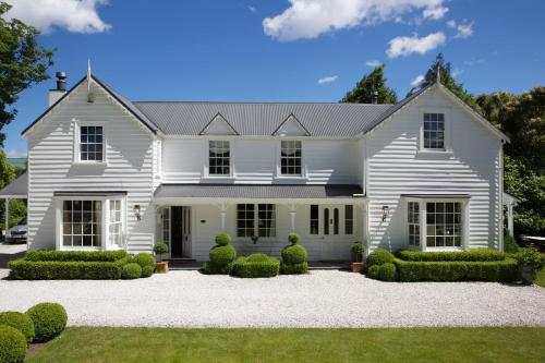 een wit huis met een aangelegde tuin bij Wyett Annex in Greytown