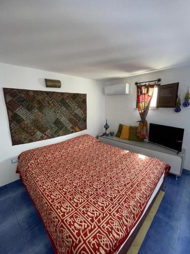 a bedroom with a bed with a red bedspread at Casa Ada - Incantevole loft in centro in Lampedusa