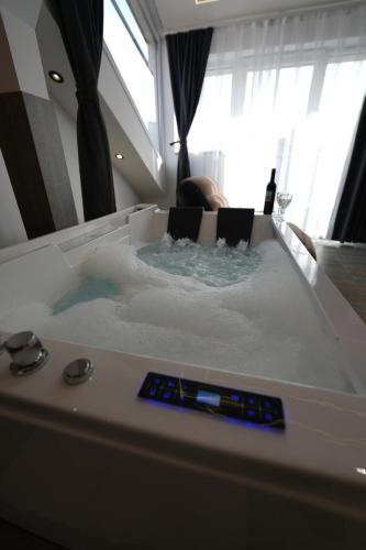 a jacuzzi tub with a person sitting in it at Hotel Besfort in Prizren