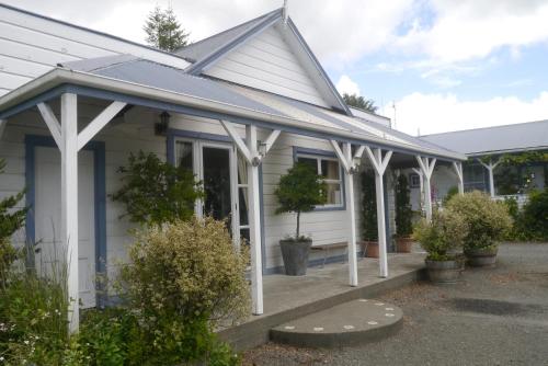 a white house with a porch with white columns at Tongariro Crossing Lodge in National Park