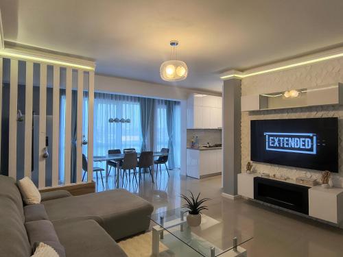 a living room with a couch and a dining room at Sunny Apartment in Oradea