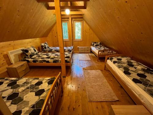 a room with three beds in a cabin at Hargitaház Mountain House in Harghita-Băi
