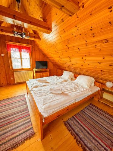 a bedroom with a bed in a wooden room at Drevenica u Starona in Liptovská Kokava