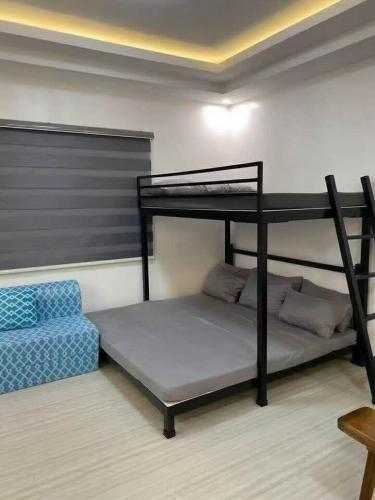 a room with two bunk beds and a couch at A&E Transient Rooms in Calatagan