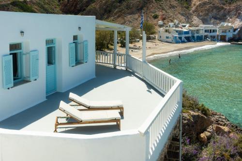 a balcony with two lounge chairs and a beach at Thavma Kalosyni in Firopótamos