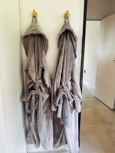 a group of towels hanging on a wall at Origin Cottage in eMalahleni