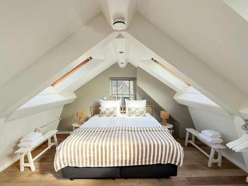 a bedroom with a bed in the attic at Tuinderswoningen Bosrijk en Zeerijk op 100m van bos en duin in Heemskerk