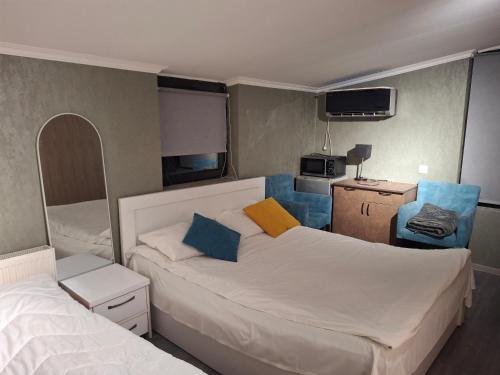 a small bedroom with two beds and a tv at Old Capital in Mtskheta