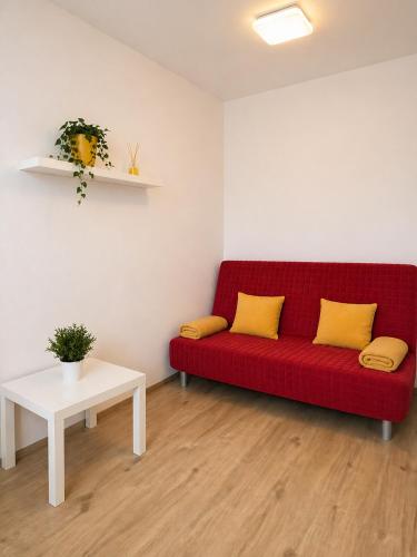 a red couch with two yellow pillows in a room at Centrum apartment in Brno
