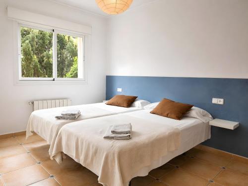 two beds in a white room with a window at Sa Torre in Llucmajor