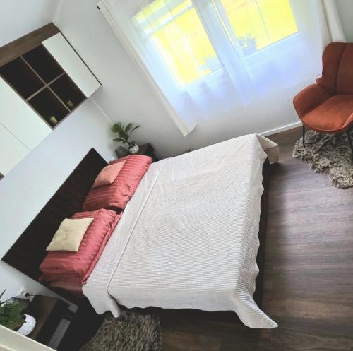 a bed with red pillows in a room with a window at Domek Leśny Potok in Sopotnia Mała