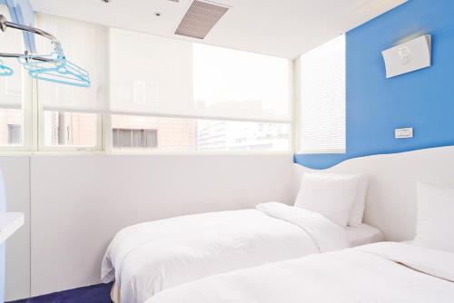 a bedroom with two beds and a window at Forever Inn in Taipei