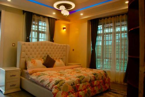 a bedroom with a bed and windows and a ceiling at Villaveh Gameview in Nakuru