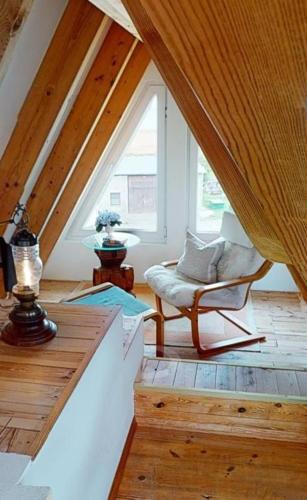 a attic room with a chair and a window at Dia Mare Taubenschlag in Ueckeritz