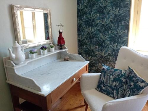 a dressing table with a mirror and a chair at Charming house in Montbron