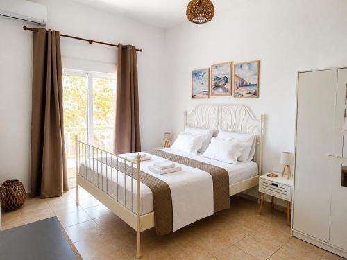 a bedroom with a white bed and a window at Sophia House in Keramoti