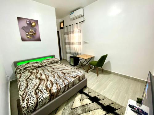a bedroom with a bed and a table and a chair at Daryl House Liberte 2 in Dakar