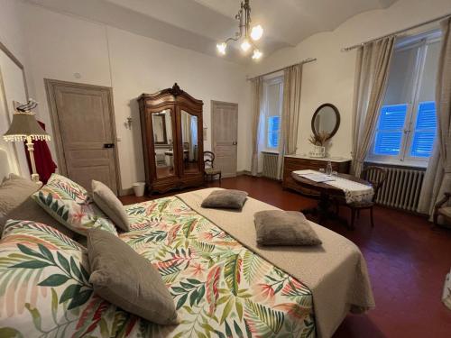 a bedroom with two beds and a table and a mirror at Maison des Ingénieurs in Molières-sur-Cèze
