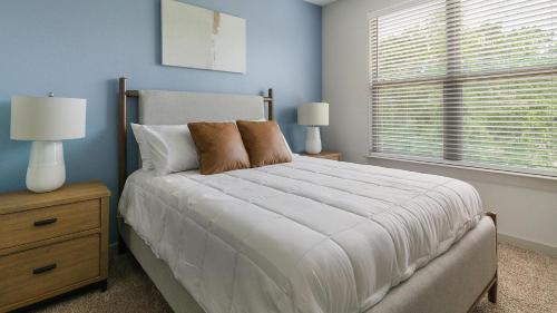 a bedroom with a bed and two lamps and a window at Landing Incredible 2BD Gym in New Caney
