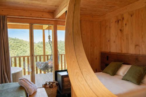 a bedroom with a canopy bed in a room with a balcony at Cabanas do Navia in Coea