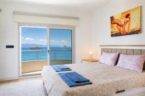 a bedroom with a bed with a view of the ocean at Villa Azure Heaven in Turgutreis