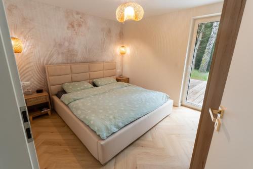 a bedroom with a bed and a large window at SoboLove in Sobolów
