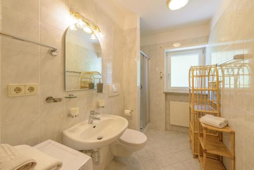 a white bathroom with a sink and a toilet at Ferienwohnungen Atz in Termeno