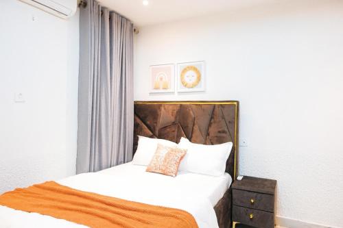a bedroom with a bed with white sheets and pillows at Amber in Tema