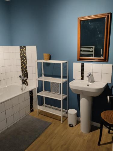 a bathroom with a sink and a bath tub and a sink at Chambres d'hôtes du Chênelong Cantal in Marchastel
