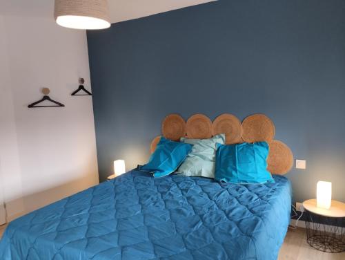 a blue bedroom with a large blue bed with blue pillows at Chambres d'hôtes du Chênelong Cantal in Marchastel