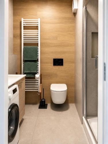 a bathroom with a toilet and a washing machine at Apartmán centrum BB s balkónom a parkovaním in Banská Bystrica
