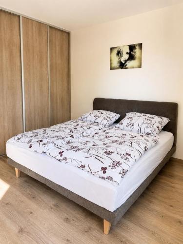 a bedroom with a bed with a white bedspread at Apartmán centrum BB s balkónom a parkovaním in Banská Bystrica