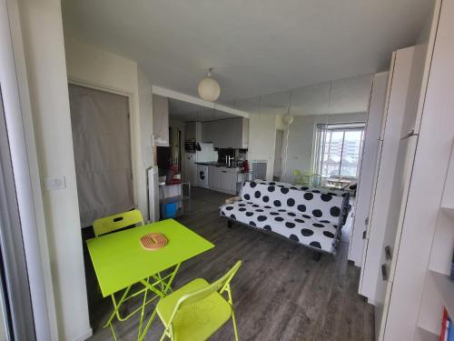 a living room with a green table and yellow chairs at Beach 50 m , vue mer in Carnon-Plage
