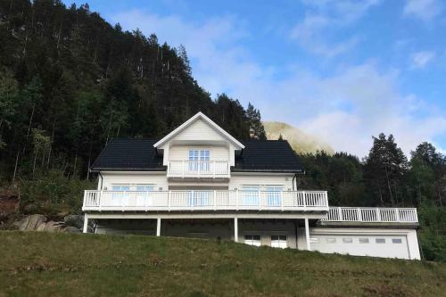 a white house on top of a hill at Vetlebekken Apartment close to Trolltunga in Steinaberg