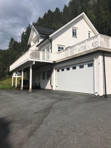 a large white house with a white garage at Vetlebekken Apartment close to Trolltunga in Steinaberg