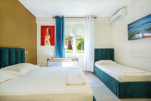 a bedroom with two beds and a window at Villa Hoxha 80 in Durrës