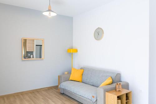 a living room with a blue couch and a mirror at My Gytheio Apartment in Gythio