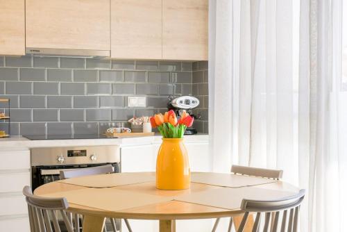a kitchen with a table with a vase of flowers on it at My Gytheio Apartment in Gythio