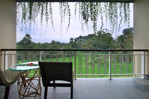a balcony with a table and chairs and a view at Byasa Ubud in Ubud
