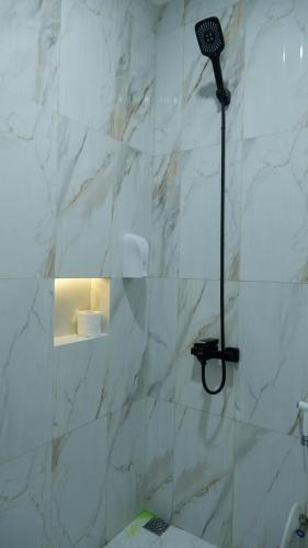 a bathroom with a shower with a white marble wall at villa NC3 31 Kota Bunga in Cikundul