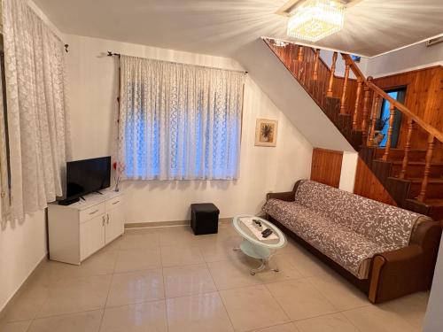 a living room with a couch and a television at Apartamani Evelin in Veliko Gradište