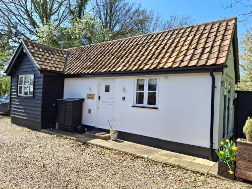a small white garage with a brown roof at The Lily Pad, Eye, Suffolk in Thornham Magna