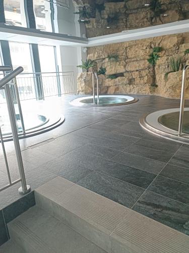 a lobby with a hot tub in a stone wall at Bel Mare Aqua 2 F504 in Międzyzdroje