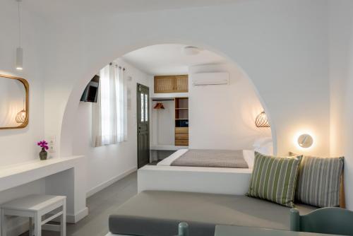 a bedroom with a bed and a couch in a room at Nissia Kamares in Kardamaina
