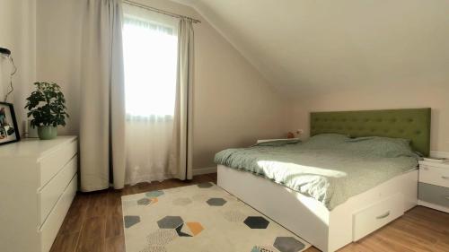 ein Schlafzimmer mit einem Bett, einem Fenster und einem Teppich in der Unterkunft SIL House in Sîntandrei
