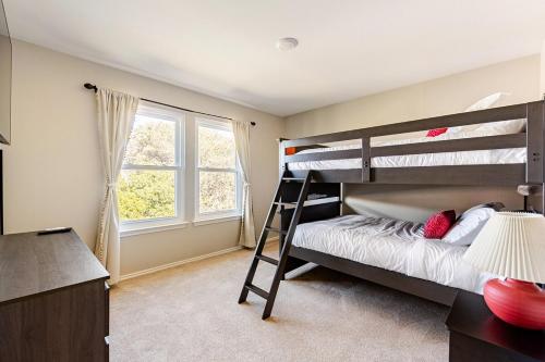 a bedroom with two bunk beds and a window at Prospect Haus Stone Oak in San Antonio
