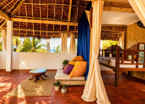a living room with a bed and a couch in a room at Karibuni Marafiki in Bwejuu