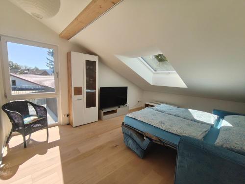 a bedroom with a bed and a flat screen tv at Am Weiher mit Terrasse in Hergensweiler