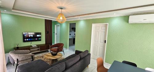 a living room with a couch and a tv at Mountain-Ridge Lux Stay in Rustenburg
